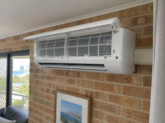 Open split-system indoor unit on a brick wall in a coastal apartment in Surfers Paradise